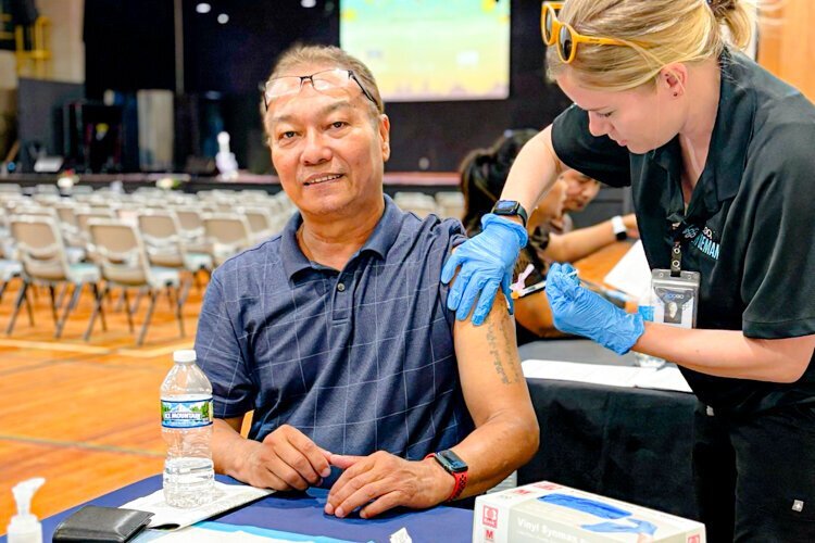 A man receives a COVID-19 vaccination at the Burma Center.