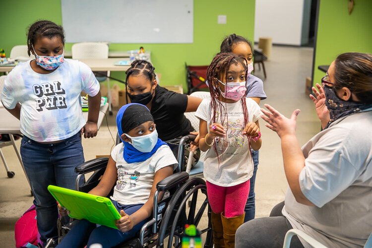 Girl Scouts in the Girl Empowerment Program receive instructions before building robots in a Robotics workshop.