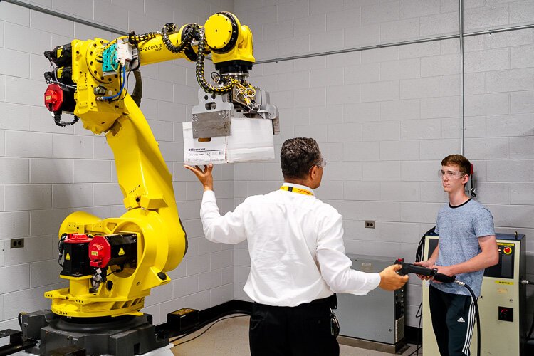 Cleveland Sparrow (left) with a student working with a robot.