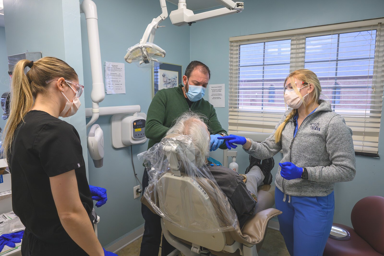 Dental hygienist Sarah Cawthon, Dr. Ken Marriott, and dental hygienist Rylee Miller treat a patient at VINA Community Dental Clinic in Brighton.