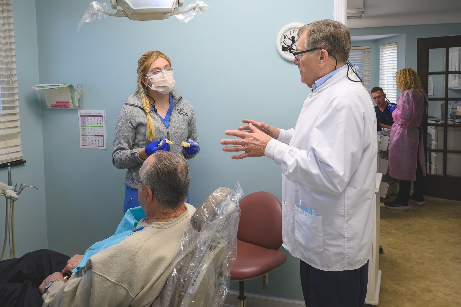 Dental hygienist Rylee Miller, patient Louie Hampton, and Dr. Howard Hamerink at the VINA Community Dental Clinic in Brighton.