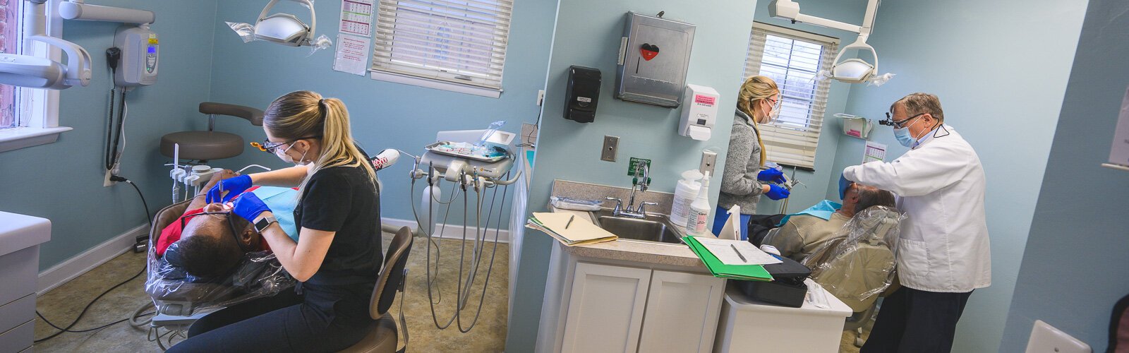 Dental hygienist Rylee Miller, patient Louie Hampton, and Dr. Howard Hamerink at the VINA Community Dental Clinic in Brighton.