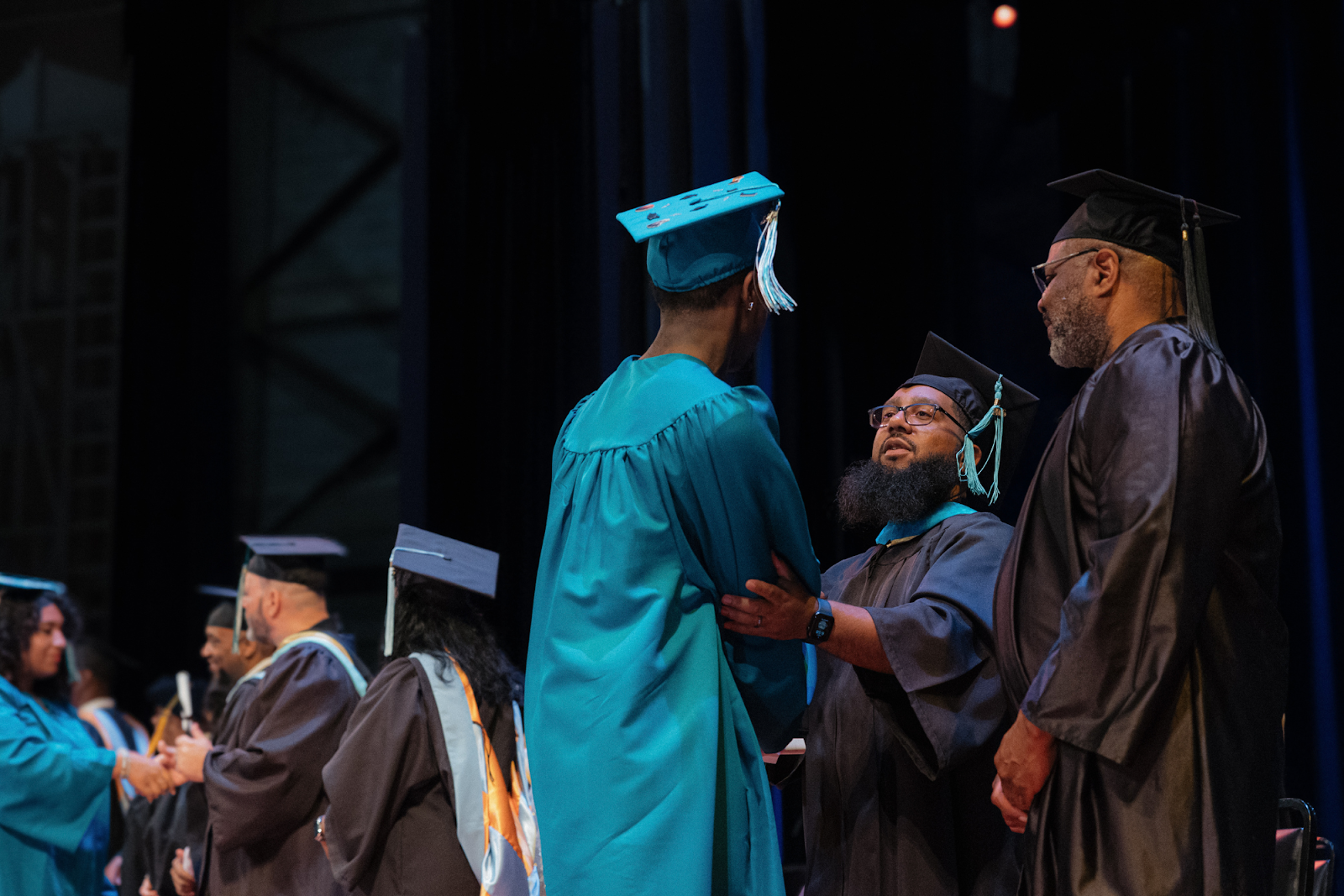 Graduates shake hands with admin as they receive their diplomas on June 4, 2024.