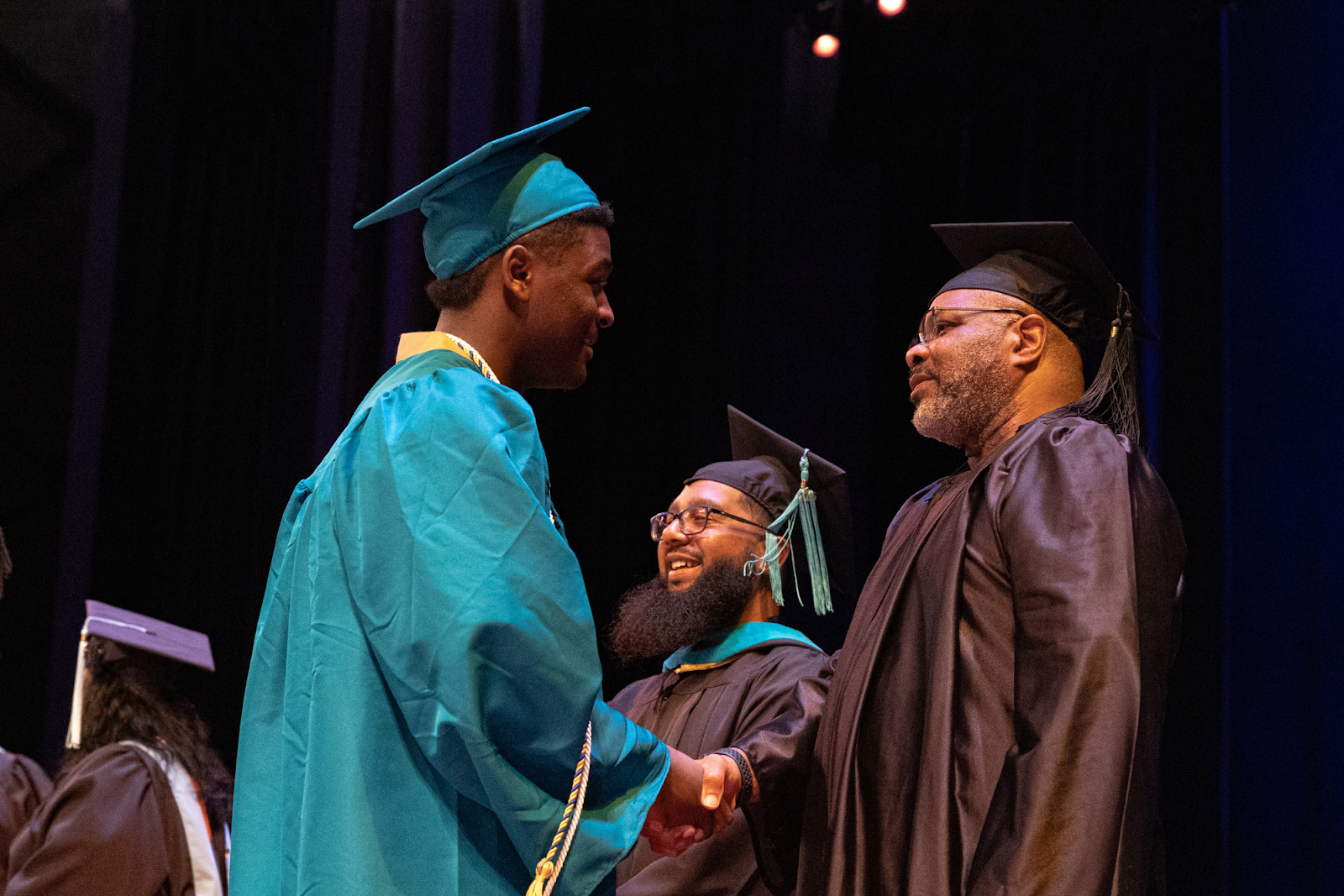 A graduate shakes hands with FCS admin on June 4, 2024. 