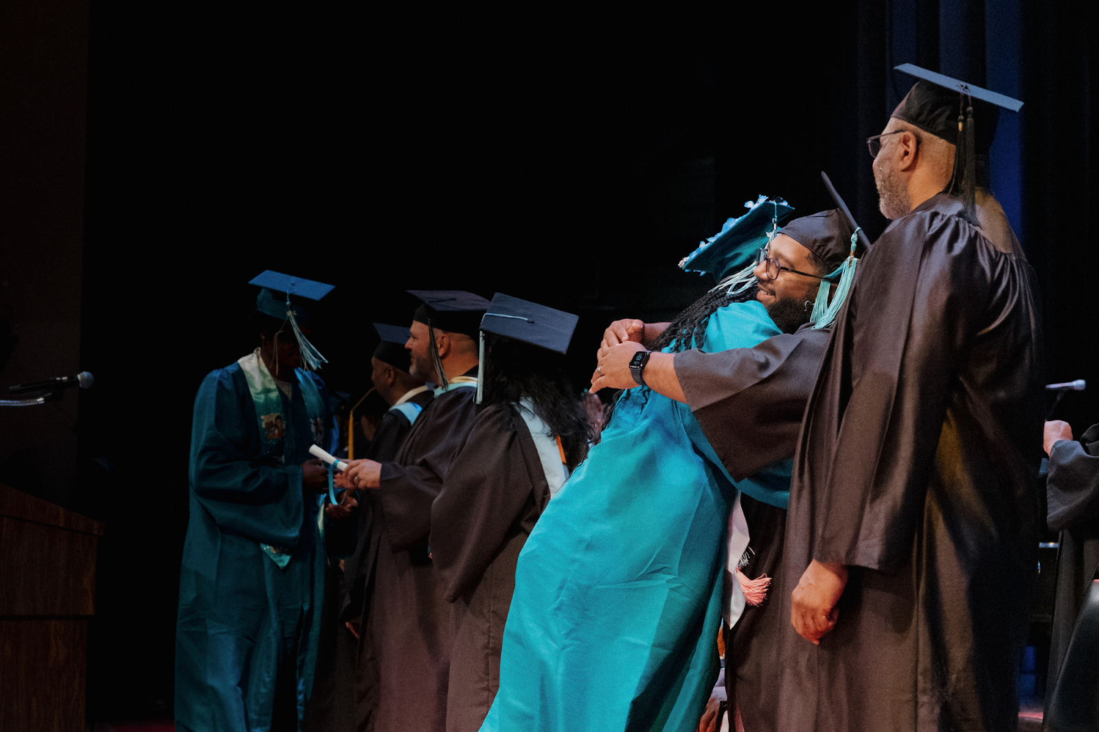 Graduates give handshakes and hugs to admin during graduation on June 4, 2024.