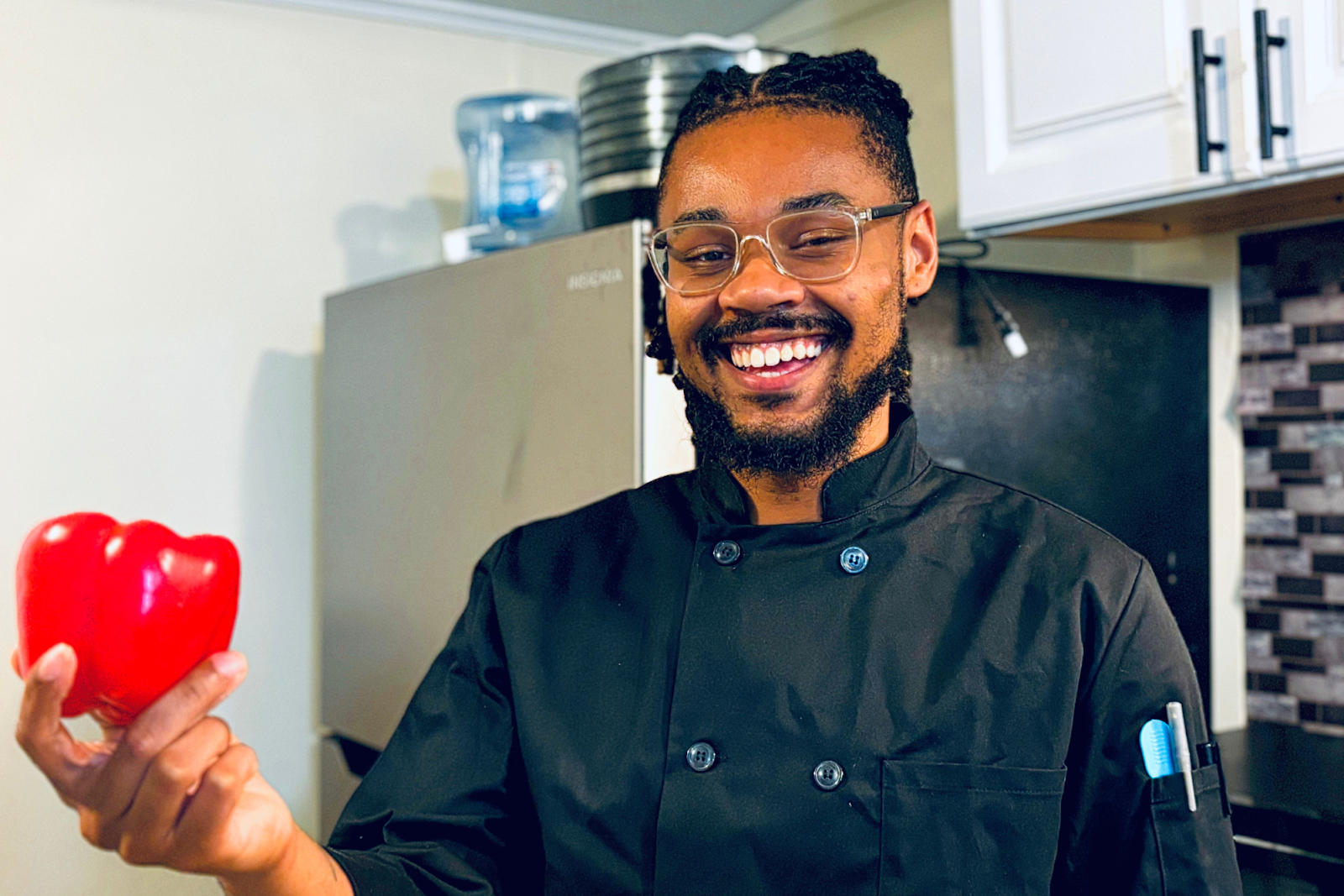 Flint native and chef Terrail Jones II is all smiles while holding a red bell pepper on July 15, 2024.