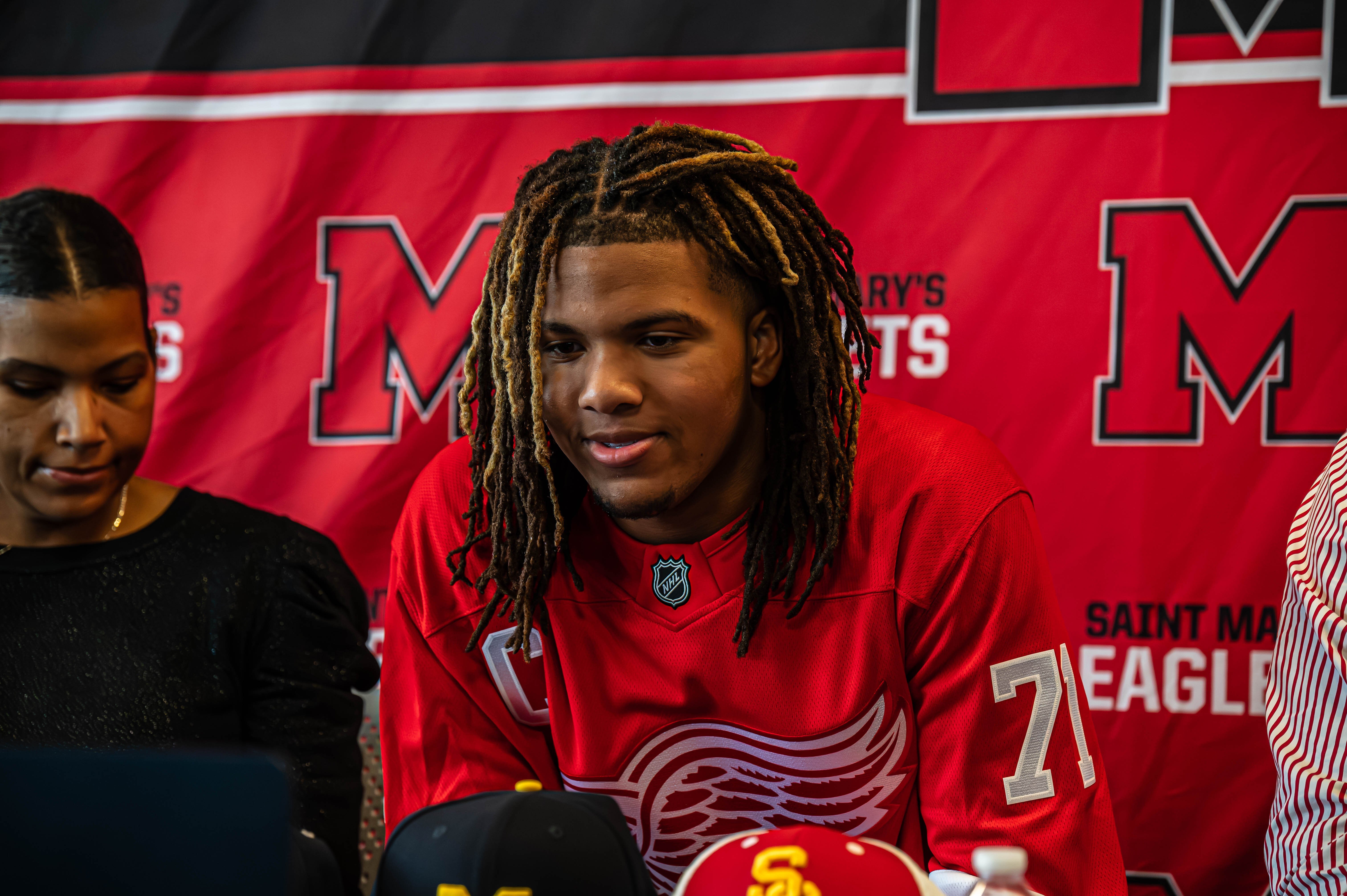 Trey McKenney with his mother and father during his announcement to commit to the Wolverines.