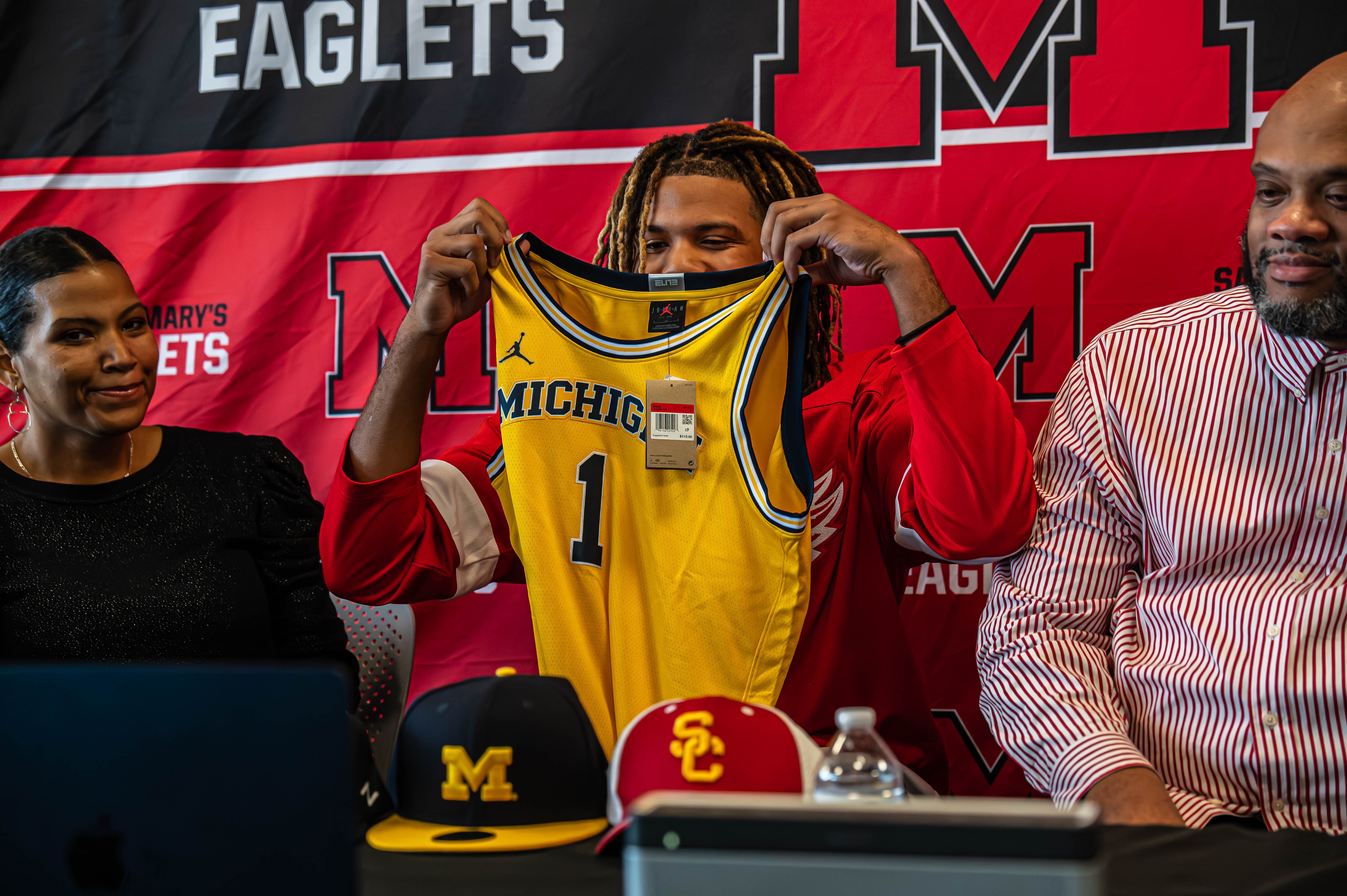 Trey McKenney with his mother and father during his commitment day decision to play for the University of Michigan.